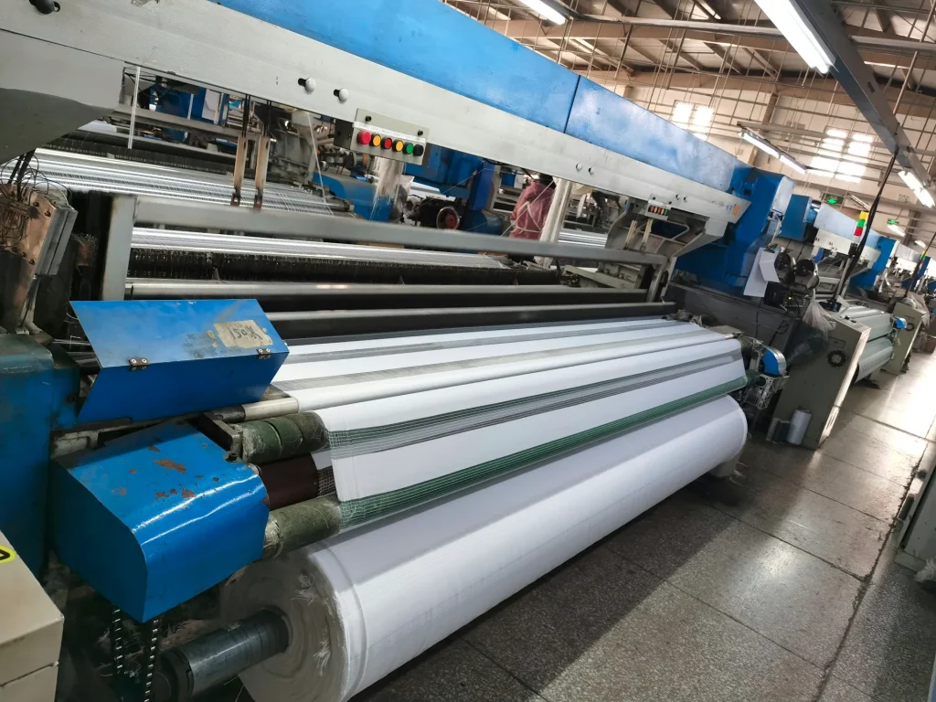 Textile or paper manufacturing machine with large rollers